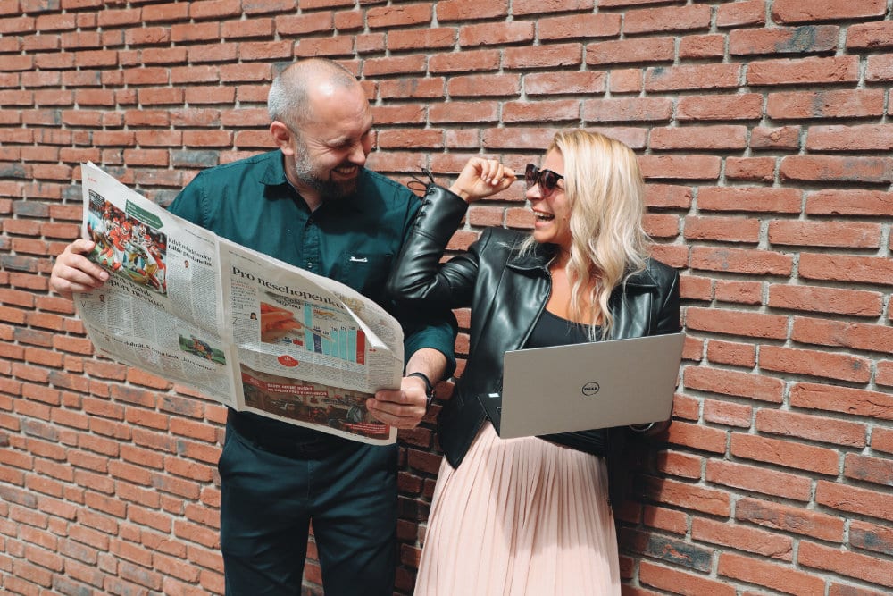 With a newspapers and notebook in front of the wall